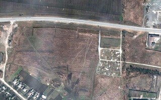 This satellite image provided by Maxar Technologies on Thursday, April 21, 2022 shows an overview of the cemetery in Manhush, some 20 kilometers west of Mariupol, Ukraine, on April 3, 2022. The graves are aligned in four sections of linear rows (measuring approximately 85 meters per section) and contain more than 200 graves